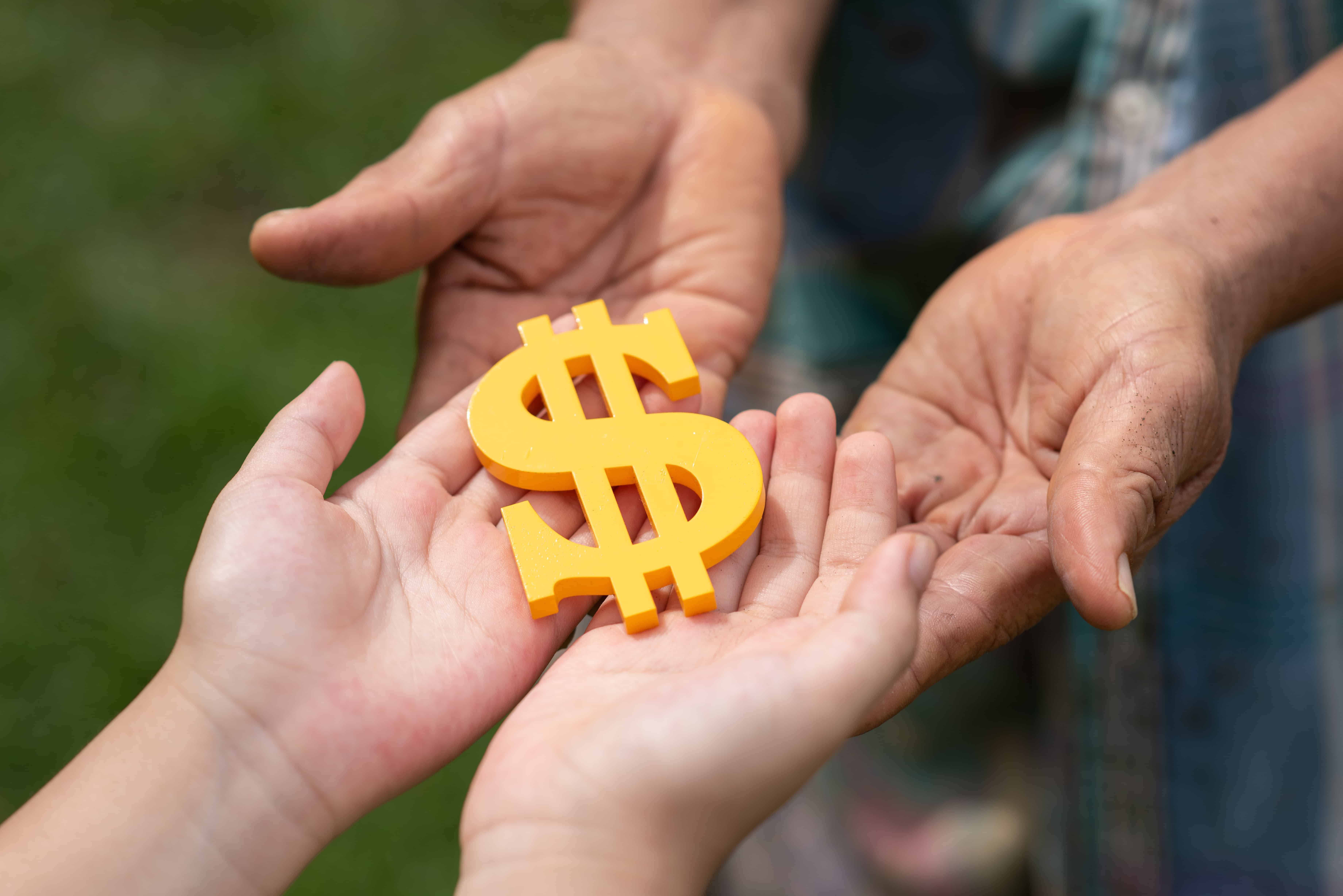 People holding a dollar sign